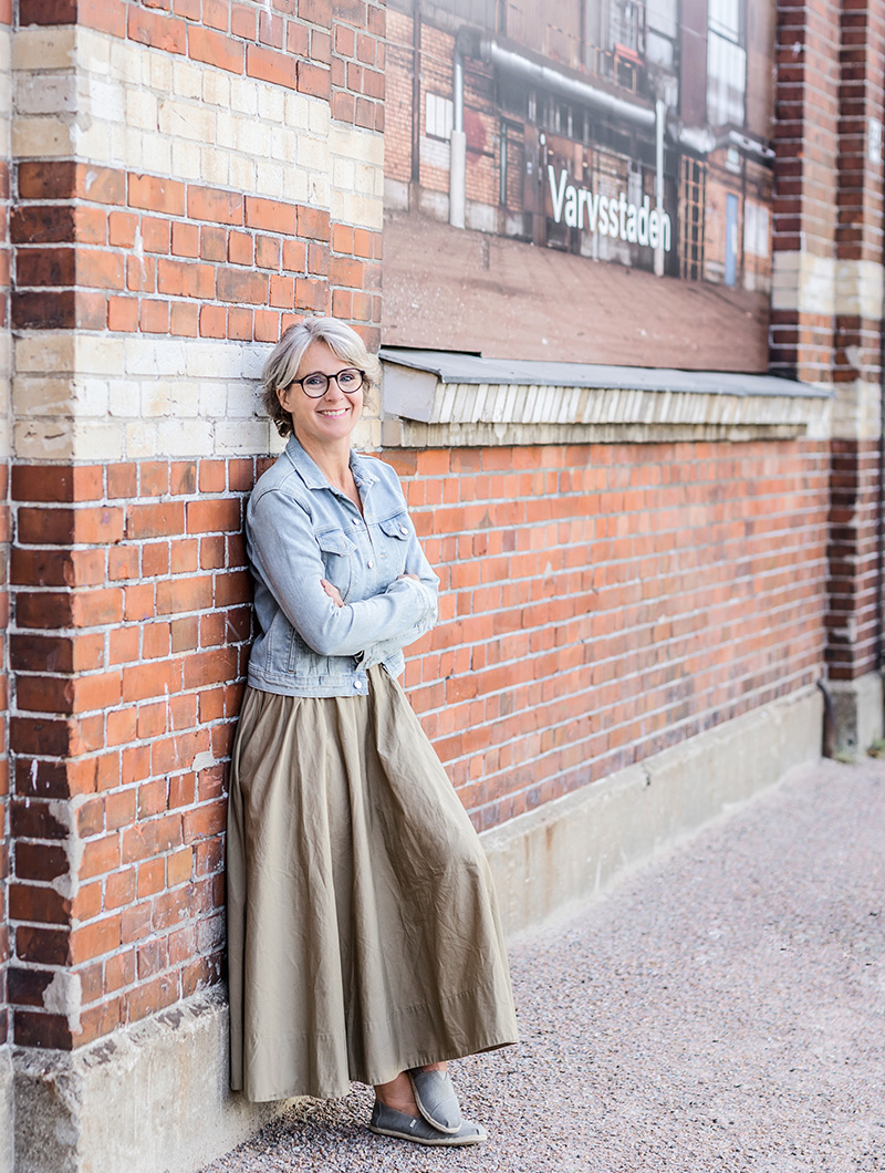 Livscoachen Charlotta står mot en tegelvägg i Malmö