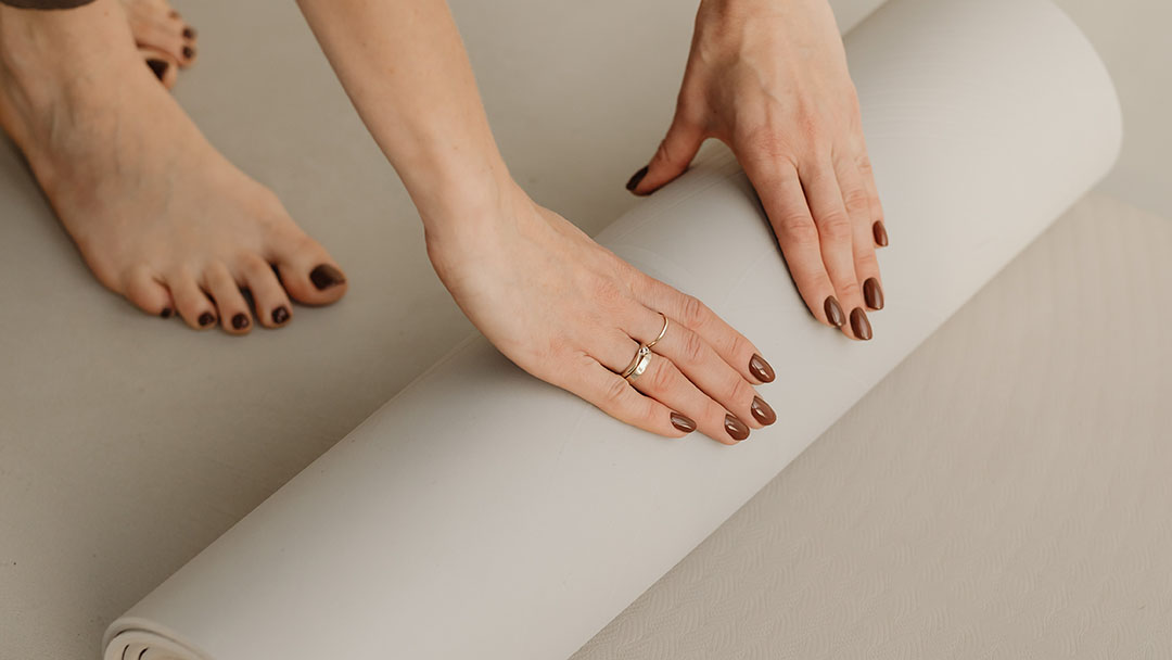 En yogamatta rullas ut av livscoachen Charlotta Hägge